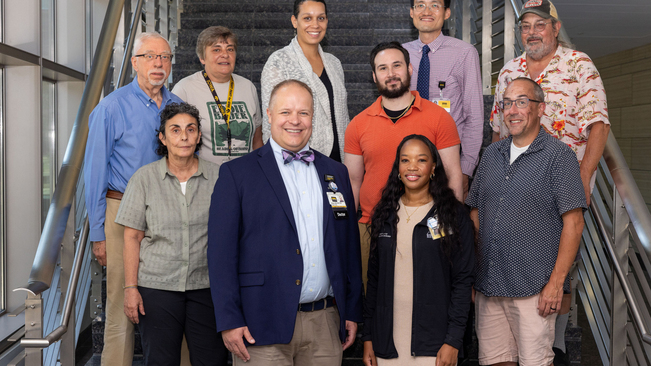 A group of faculty pose on a staircase.