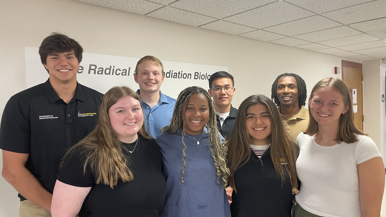 A group of students pose in an office.